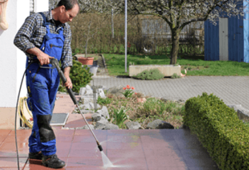 guy with a pressure washer washing house front